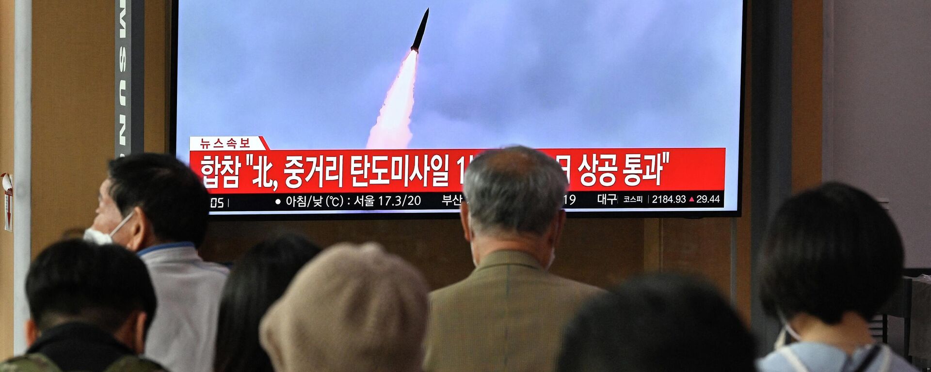 People watch a television screen showing a news broadcast with file footage of a North Korean missile test, at a railway station in Seoul on October 4, 2022 - Sputnik International, 1920, 08.10.2022