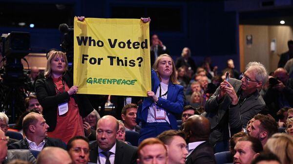 Greenpeace activists hold a banner reading 'Who voted for This?' as Britain's Prime Minister Liz Truss delivers her speech to the 2022 Conservative Party conference - Sputnik International