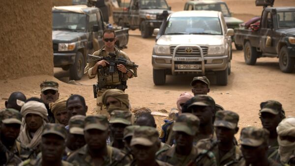 In this July 27, 2013 file photo, a French soldier stands watch behind Malian soldiers during a visit by the head of France's Operation Serval and Mali's army chief of staff to a Malian army base in Kidal, Mali. - Sputnik International
