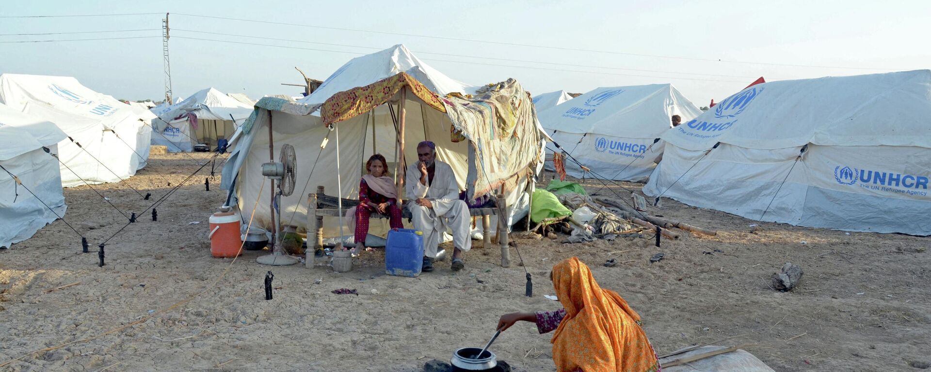 A displaced flood-affected woman cooks food for her family at a makeshift camp at Sohbatpur in Jaffarabad district of Balochistan province on October 4, 2022. - Sputnik International, 1920, 06.10.2022