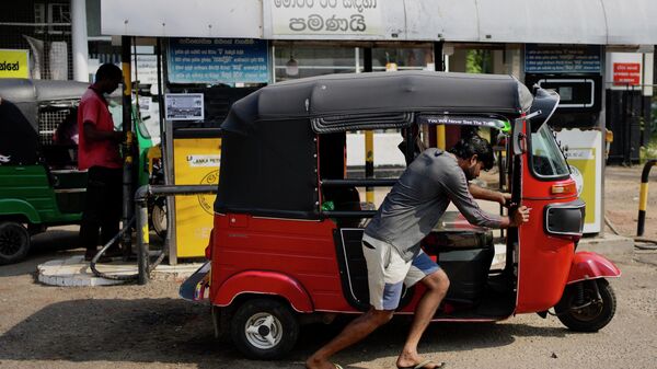 A man pushes his autorickshaw to a fuel station in Colombo, Sri Lanka, Wednesday, July 27, 2022. - Sputnik International