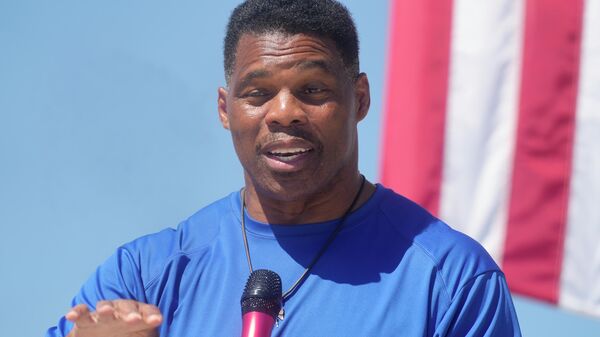 Georgia GOP Senate nominee Herschel Walker smiles during remarks during a campaign stop at Battle Lumber Co. on Thursday, Oct. 6, 2022, in Wadley, Ga. Walker's appearance was his first following reports that a woman who said Walker paid for her 2009 abortion is actually mother of one of his children - undercutting Walker's claims he didn't know who she was. - Sputnik International