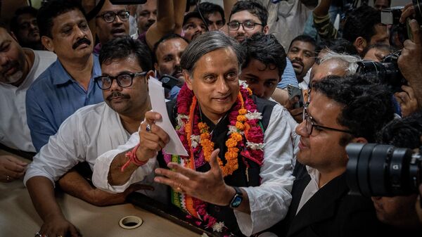 Senior Congress party leader Shashi Tharoor, right, shows his documents as he files his nomination papers for the position of Congress party president, at the party's headquarter in New Delhi, India, Friday, Sept. 30, 2022. - Sputnik International