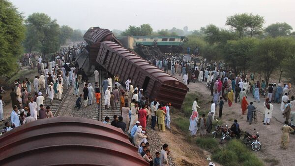 Pakistani residents gather beside the wreckage at the site of the collision of two trains on the outskirts of Multan on September 15, 2016.  - Sputnik International