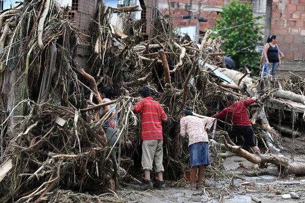 Residents search for their missing relatives in the rubble of a house destroyed by a landslide during heavy rains in Las Tejerias, Aragua state, Venezuela, on October 9, 2022. - Sputnik International
