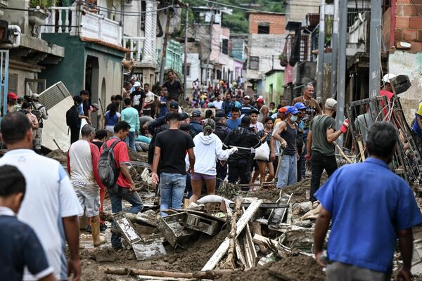 Residents walk among the rubble of destroyed houses washed away by a landslide during heavy rains in Las Tejerias, Aragua state, Venezuela, on October 9, 2022.  - Sputnik International