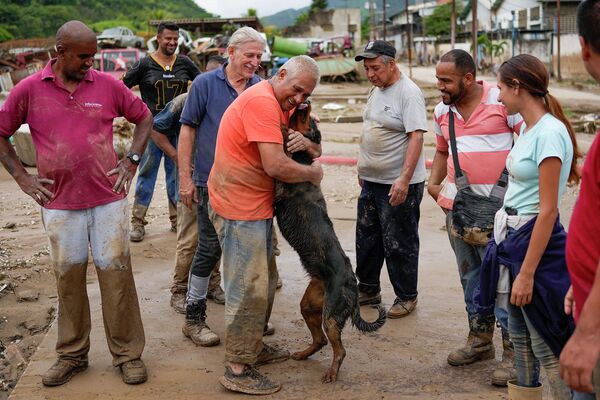 A man reunites with his dog, rescued by neighbors from the mud, after flooding caused by intense rains in Las Tejerias, Venezuela, Sunday, Oct. 9, 2022. - Sputnik International