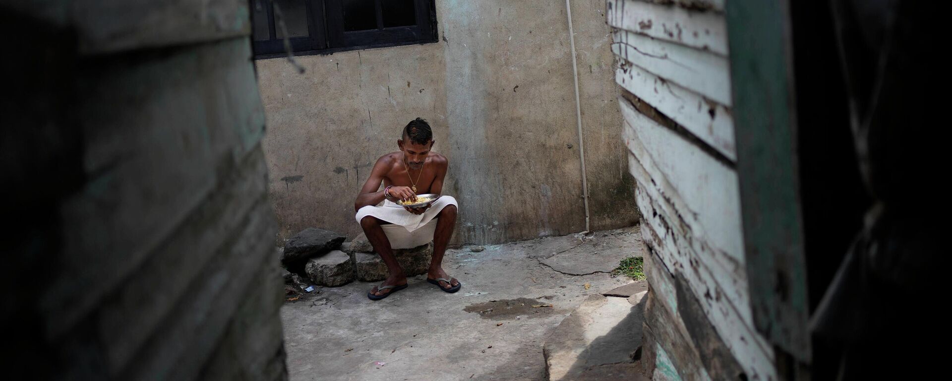 A man eats a meal outside his shanty in Colombo, Sri Lanka, Wednesday, Oct. 5, 2022. - Sputnik International, 1920, 11.10.2022