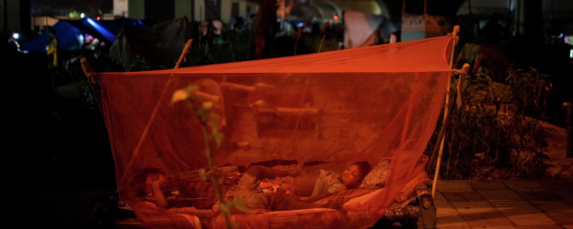 Children sleep on a cot covered with a mosquito net in their temporary shelter after their homes for inundated with floodwaters in New Delhi, India, Thursday, Sept. 29, 2022. - Sputnik International, 1920, 11.10.2022