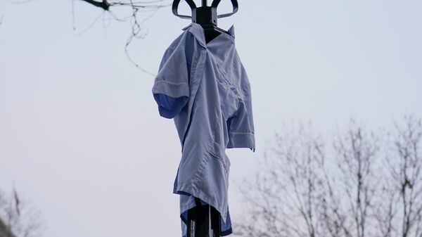 An NHS uniform is hung at a lamp, during an anti vaccines protest, in London, Saturday, Jan. 22, 2022. - Sputnik International