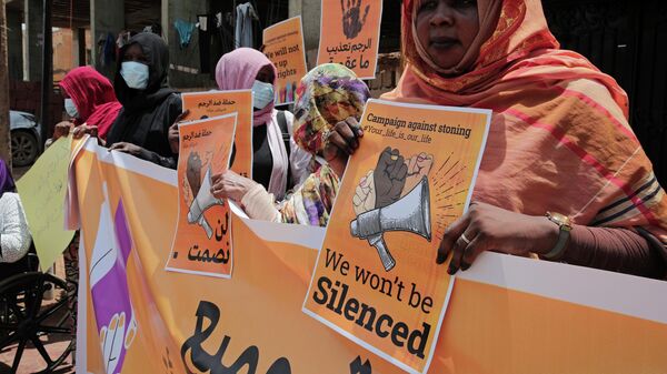 Women chant slogans and hold signs protesting violence against women and against women being sentenced to stoning for adultery, in front of the U.N. rights office in Khartoum, Sudan, Wednesday, Sept. 14, 2022.  - Sputnik International