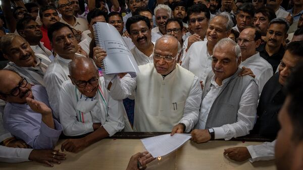 Senior Congress party leader Mallikarjun Kharge, center, shows his documents as he files his nomination papers for Congress party president at the party's headquarter in New Delhi, India, Friday, Sept. 30, 2022. - Sputnik International
