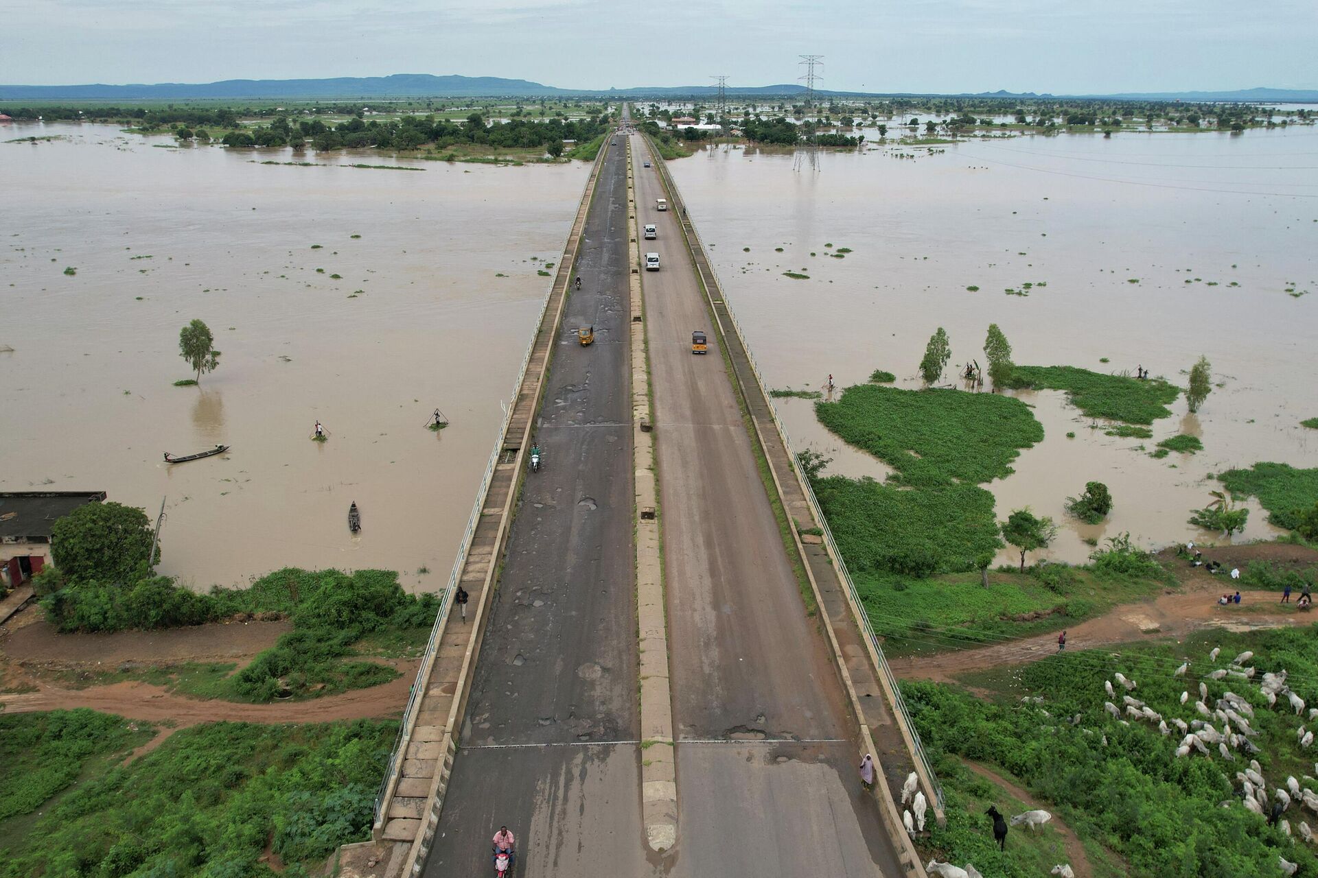 This aerial view shows local residents crossing the Numan bridge while driving to a safer grounds on September 25, 2022 away from the rising waters in Numan Community of Adamawa State - North East Nigeria. - Sputnik International, 1920, 22.10.2022
