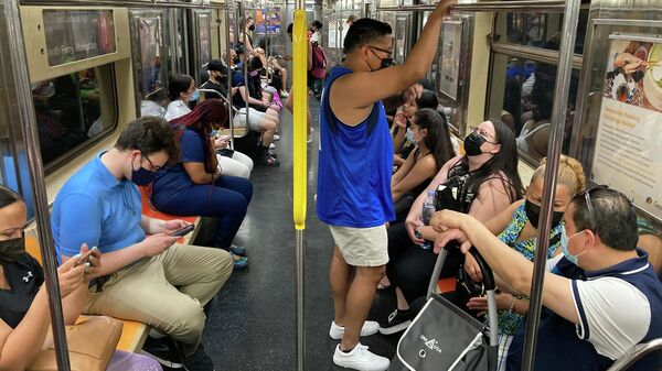 Commuters wear face masks while riding the subway in New York, June 6, 2021. New York state is dropping its mask requirement on public transportation thanks in part to the availability of new booster shots targeting the most common strain of COVID-19, Gov. Kathy Hochul announced Wednesday, Sept. 7, 2022. - Sputnik International