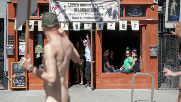People cheer from a bar as nudists march along during the Nude Love Parade in San Francisco, California on March 17, 2019 - Sputnik International