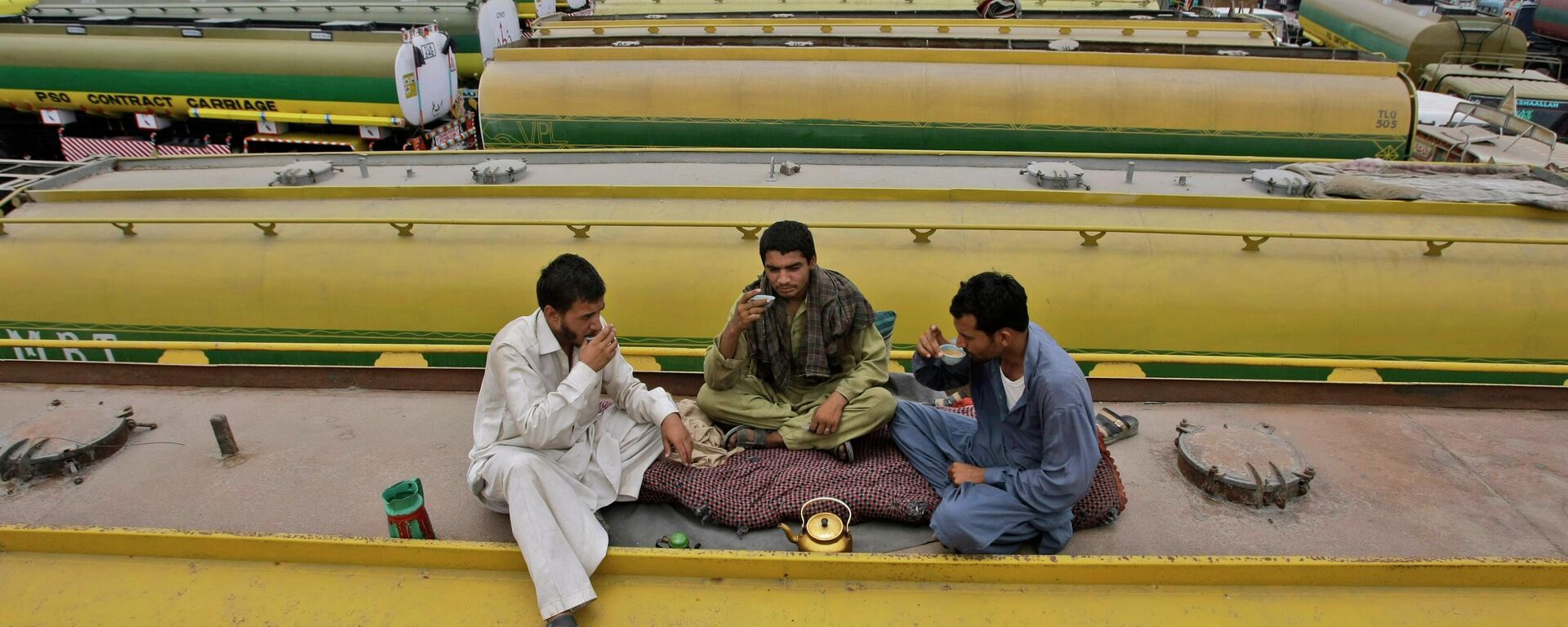 Pakistani drivers, drink tea on top of an oil tanker, which was used to transport NATO fuel supplies to Afghanistan, while parked with other tankers in a compound in Karachi, Pakistan, Monday, June 4, 2012. - Sputnik International, 1920, 18.10.2022
