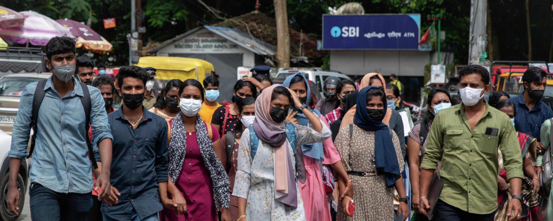 Job aspirants wearing face masks cross a street as they arrive for interviews organized by the state run employability center in Kochi, Kerala state, India - Sputnik International, 1920, 18.10.2022