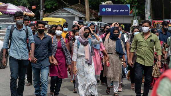 Job aspirants wearing face masks cross a street as they arrive for interviews organized by the state run employability center in Kochi, Kerala state, India - Sputnik International