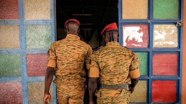 Two soldiers enter the Catholic church at the 10th RCAS army barracks in Kaya, Burkina Faso, Saturday, April 10, 2021 - Sputnik International