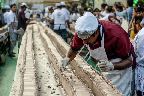 Пекарь готовит пирог длиной около 6,5 км в попытке побить мировой рекорд Гиннесса по самому длинному торту в Триссуре в южно-индийском штате Керала 15 января 2020 года - Sputnik International