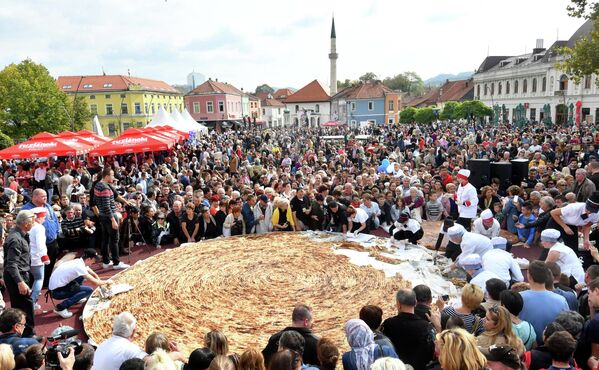 Боснийские повара и их подмастерья нарезают самый большой в мире пирог с мясным фаршем, известный как бурек, на центральной площади в Тузле - Sputnik International