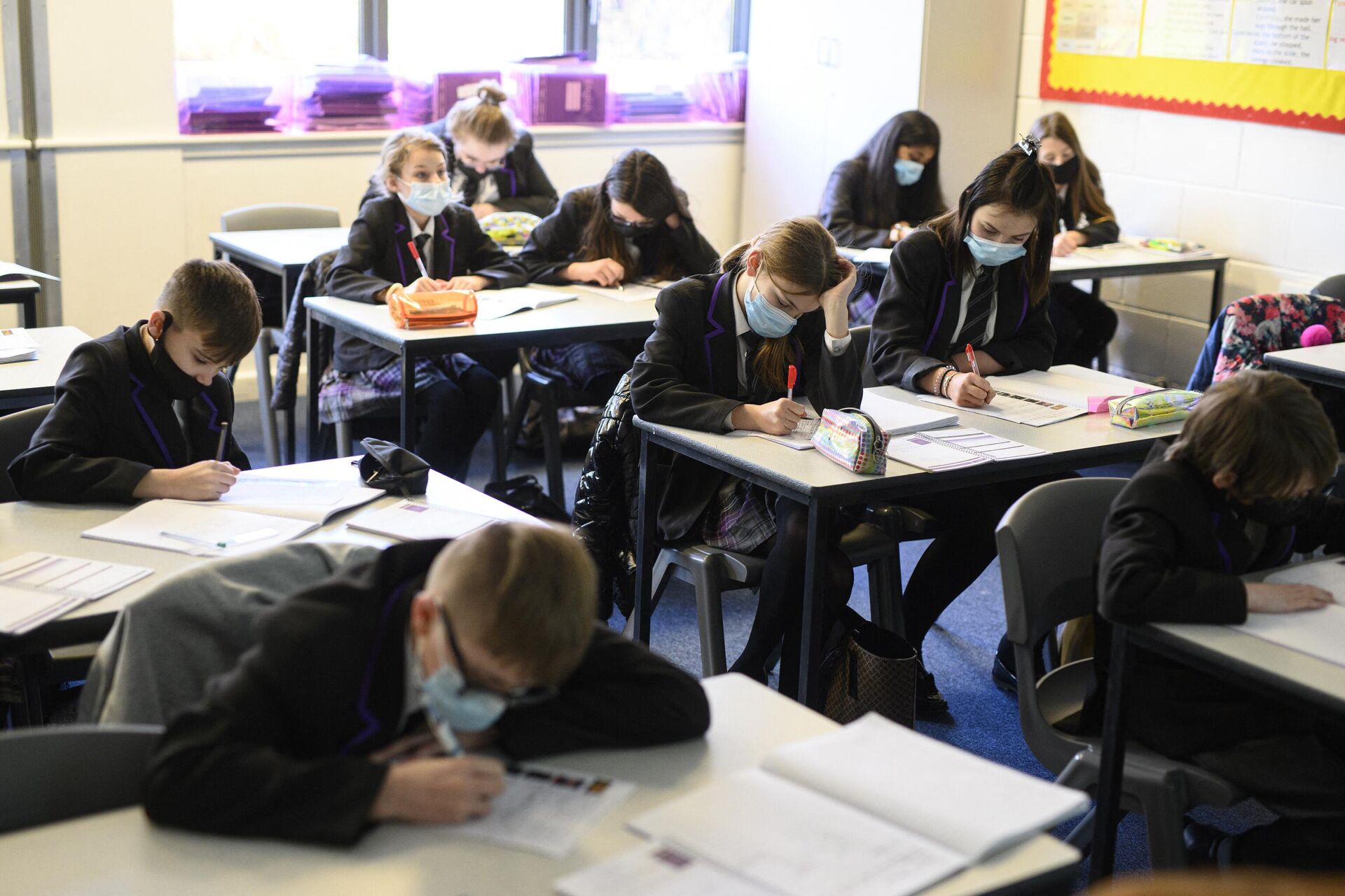 Year 8 students wear face masks or coverings to mitigate the spread of Covid-19, as they take part in an English class at Park Lane Academy in Halifax, northwest England on January 4, 2022. (Photo by OLI SCARFF / AFP) - Sputnik International, 1920, 23.10.2022