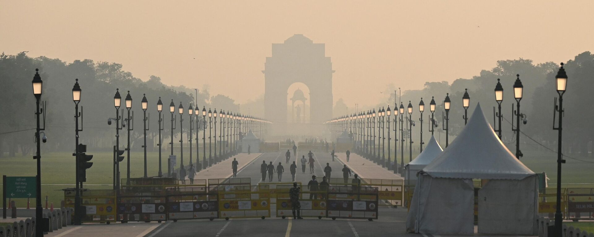 People walk along a road near India Gate amid smoggy conditions in New Delhi on October 25, 2022. - Sputnik International, 1920, 25.10.2022