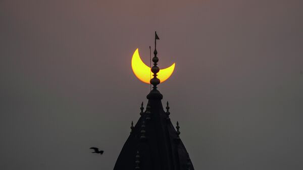 A partial solar eclipse is seen behind the centuries-old Raghunath Hindu temple in Srinagar, Indian controlled Kashmir, Tuesday, Oct. 25, 2022. - Sputnik International