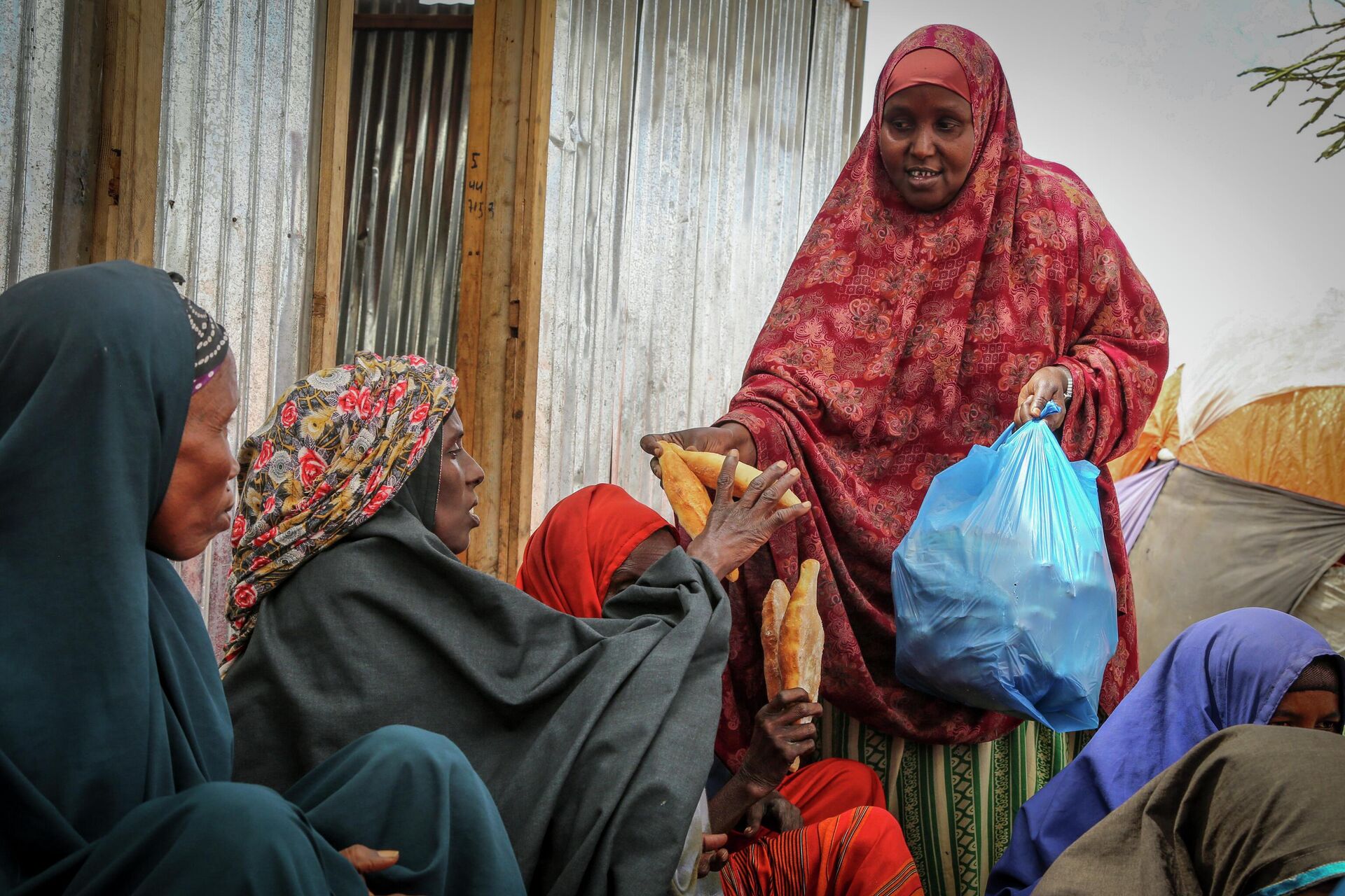 Somalis who fled drought-stricken areas receive charitable food donations from city residents after arriving at a makeshift camp for the displaced on the outskirts of Mogadishu, Somalia on June 30, 2022 - Sputnik International, 1920, 03.03.2023