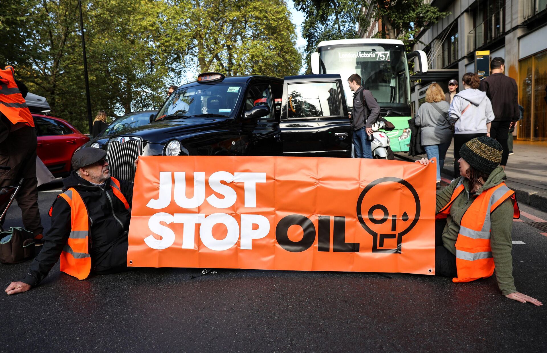 Members of the environmental activist group Just Stop Oil hold a banner as they block Park Lane, in central London, on October 16, 2022 as part of a series of actions. - Sputnik International, 1920, 28.10.2022