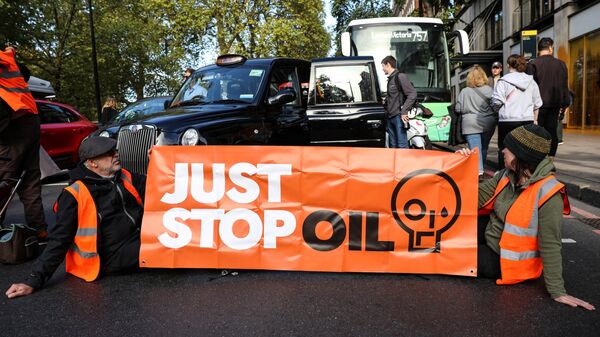 Members of the environmental activist group Just Stop Oil hold a banner as they block Park Lane, in central London, on October 16, 2022 as part of a series of actions. - Sputnik International