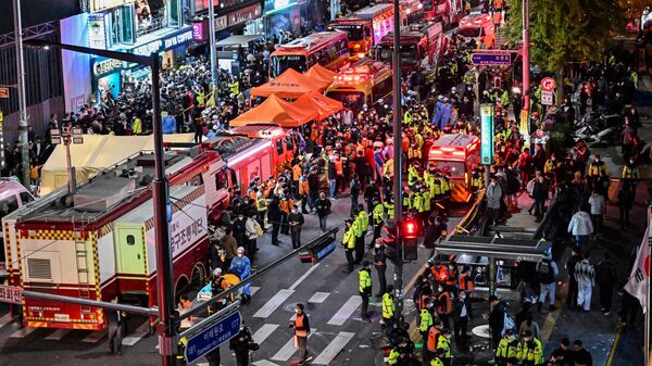 Onlookers, police and paramedics gather where dozens of people suffered cardiac arrest, in the popular nightlife district of Itaewon in Seoul on October 30, 2022. - Sputnik International