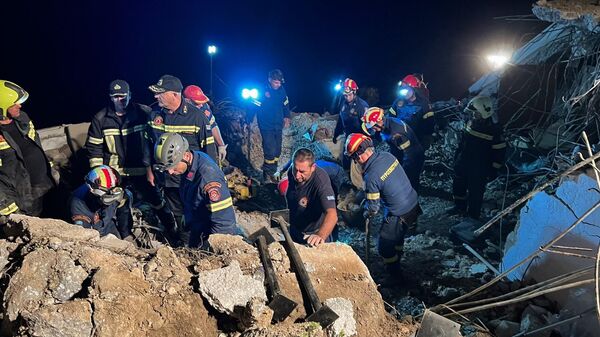 Firemen search in debris after a landslide in Agia Fotia, near Koutsounari, southeastern Crete, on October 30, 2022. - A 45-year-old tourist from the Czech Republic was killed in a landslide on the building where she was staying on the Greek island of Crete overnight from Saturday to Sunday. Her son and husband were found alive in the rubble in Agia Fotia, in southeastern Crete, Greece's largest island. (Photo by Jason Tavlas / AFP) - Sputnik International