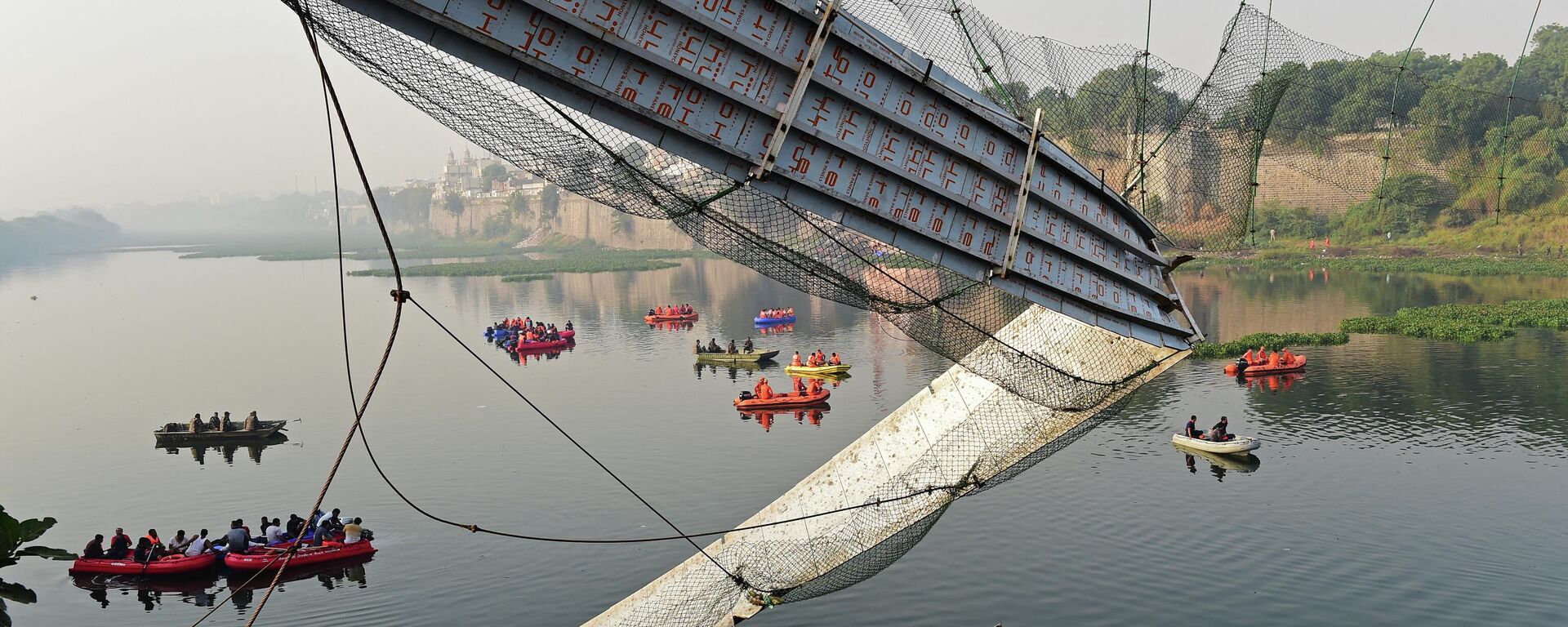Rescue personnel conduct search operations after a bridge across the river Machchhu collapsed at Morbi in India's Gujarat state on October 31, 2022 - Sputnik International, 1920, 31.10.2022