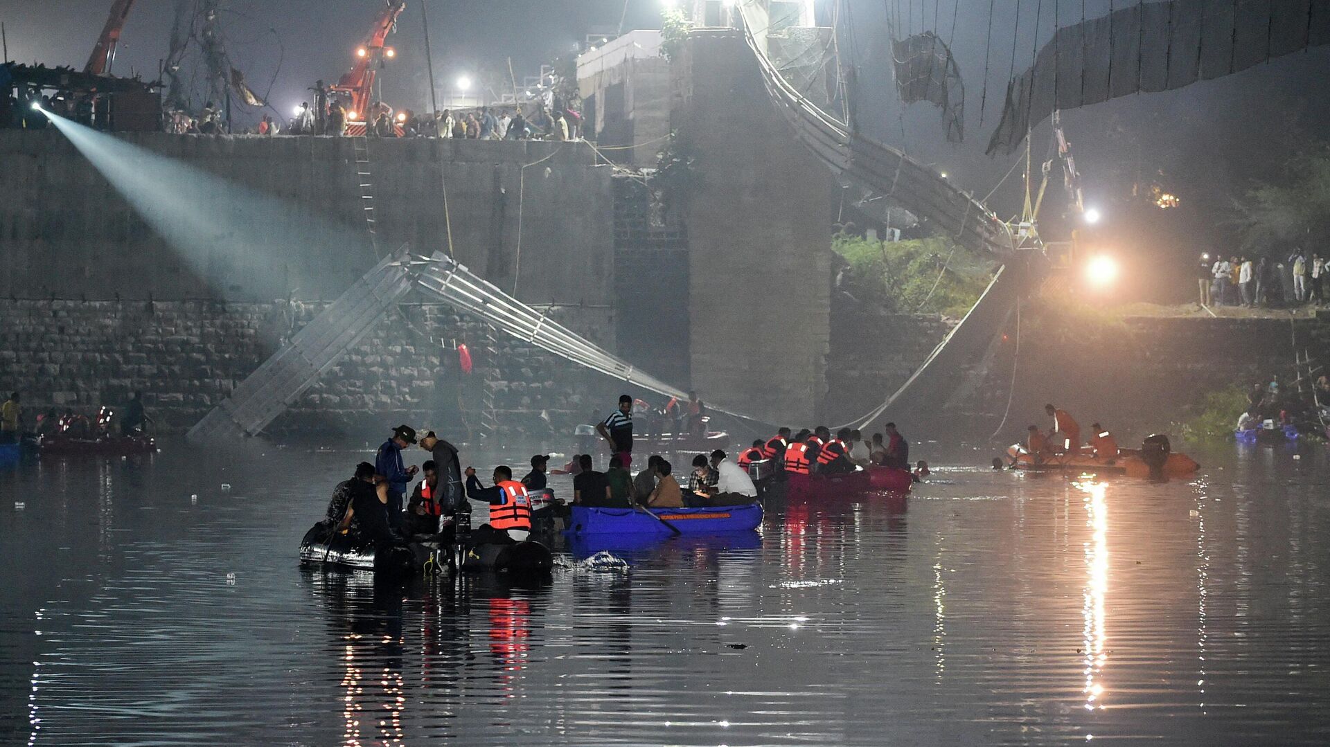 Indian rescue personnel conduct search operations after a bridge across the river Machchhu collapsed in Morbi, some 220 kms from Ahmedabad, early on October 31, 2022 - Sputnik International, 1920, 31.10.2022