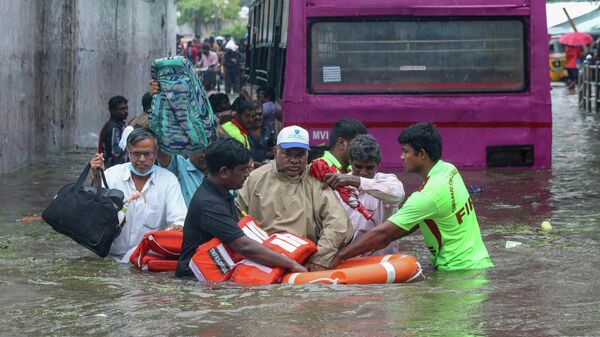 A passenger, wearing cap, of a bus that got stuck in an underpass that was flooded due to heavy rains is rescued by members of the Fire and Rescue department in Chennai, India, Tuesday, Nov.1, 2022. - Sputnik International