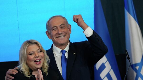 Former Israeli Prime Minister and the head of Likud party, Benjamin Netanyahu and his wife Sara gesture after first exit poll results for the Israeli Parliamentary election at his party's headquarters in Jerusalem, Wednesday, Nov. 2, 2022.  - Sputnik International