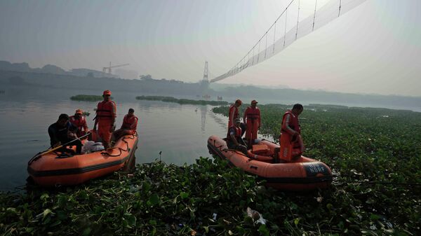 Rescuers on boats search in the Machchhu river next to a cable bridge that collapsed on Sunday in Morbi town of western state Gujarat, India, Wednesday, Nov. 2, 2022. - Sputnik International
