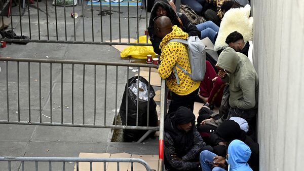 Asylum seekers wait outside the headquarters of the Fedasil Federal Agency, where the registration of asylum seekers starts, in Brussels on August 29, 2022. - Sputnik International