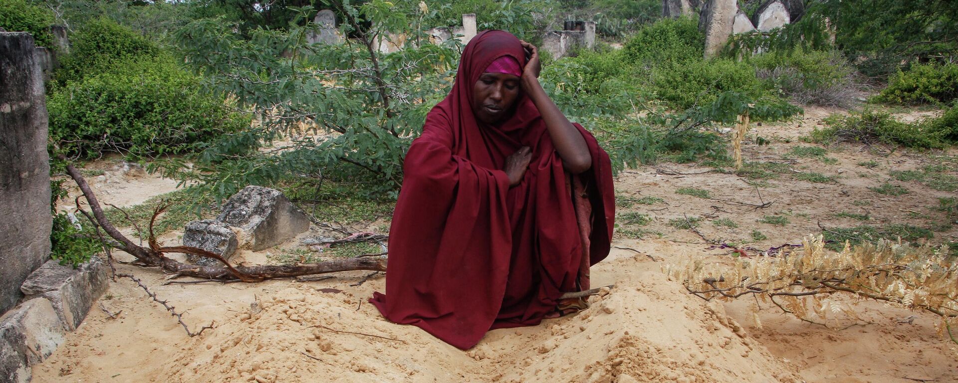 Fatuma Abdi Aliyow sits by the graves of her two sons who died of malnutrition-related diseases last week, at a camp for the displaced on the outskirts of Mogadishu, Somalia, Sept. 3, 2022. - Sputnik International, 1920, 04.11.2022