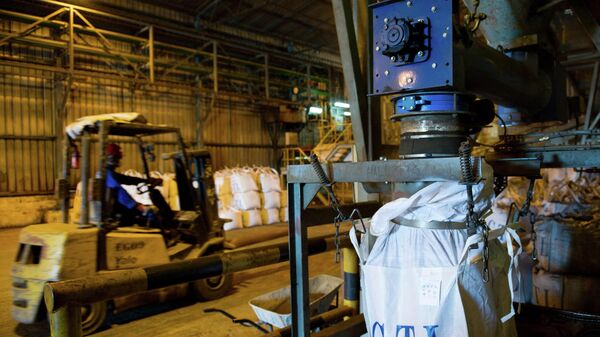 A worker drives a fork-lift past a machine pouring a mixture of copper and cobalt in a bag at the STL (Société pour le traitement du terril de Lubumbashi or Company for the treatment of the slap heap of Lubumbashi) processing plant in Lubumbashi during a maintenance day on December 1, 2011. - Sputnik International
