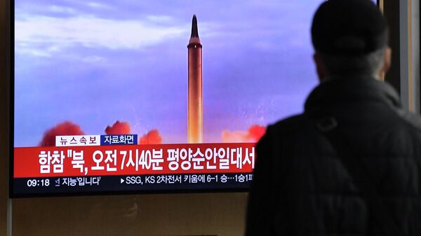 A man watches a television screen showing a news broadcast with file footage of a North Korean missile test, at a railway station in Seoul on November 3, 2022 - Sputnik International