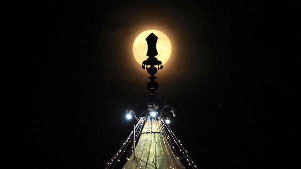 The full moon is seen above an illuminated Gurdwara on the occasion of Gurpurab, the 550th birth anniversary of Sikhism founder Guru Nanak Dev, at New Chandigarh in Punjab state on November 12, 2019 - Sputnik International