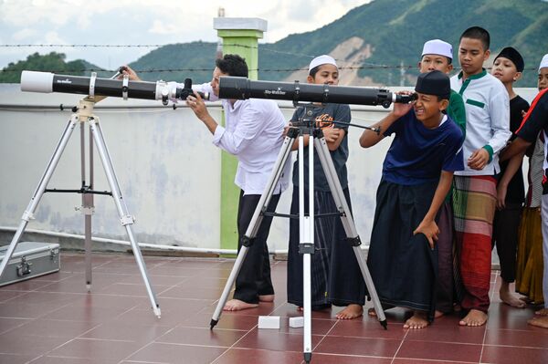 Учащиеся исламской школы-интерната смотрят в телескопы, готовясь наблюдать лунное затмение в Аджуне, Индонезия - Sputnik International