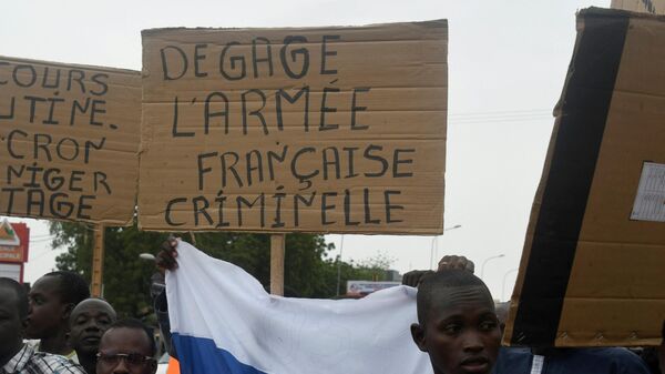 A man holds a placard reading Clear off criminal French army as people demonstrate against French military presence in Niger on September 18, 2022 in Niamey. - Sputnik International