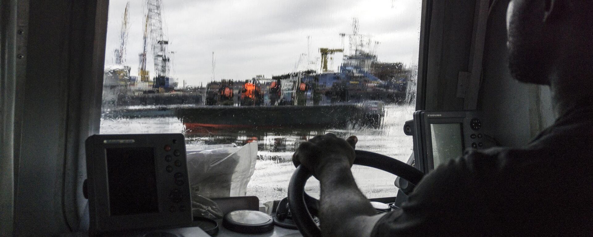 A member of the NNS Delta Of the Nigerian Navy forces steers a boat through the port area on April 19, 2017 in the Niger Delta region near the city of Port Harcourt. - Sputnik International, 1920, 12.11.2022