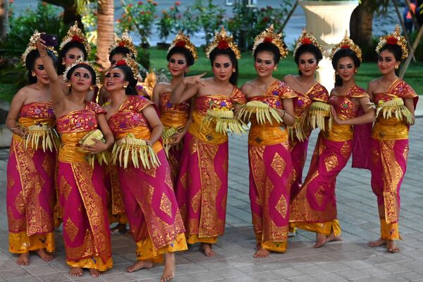 Балийские танцовщицы в традиционных нарядах делают селфи в ожидании прибытия лидеров G20 в международный аэропорт в Тубане, Бали - Sputnik International