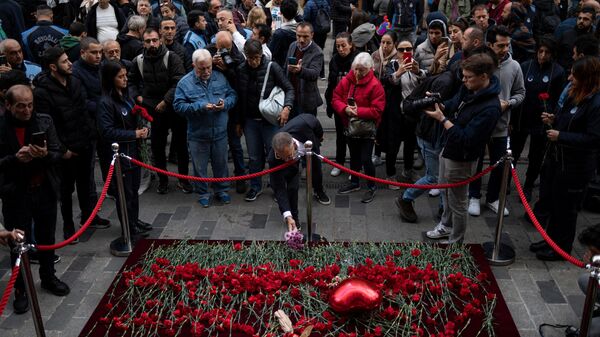 A mourner lays flowers as people grieve the victims of November 13 explosion at the busy shopping street of Istiklal in Istanbul on November 14, 2022.  - Sputnik International