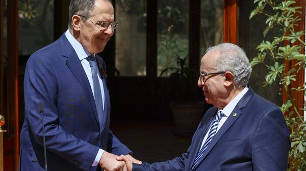 In this handout photo released by the Russian Foreign Ministry press service, Russian Foreign Minister Sergei Lavrov, left, and Algerian President Abdelmadjid Tebboune shake hands after a joint news conference following their talks at El Mouradia Palace, the official residence of the president, in Algiers, Algeria, on Tuesday, May 10, 2022. - Sputnik International