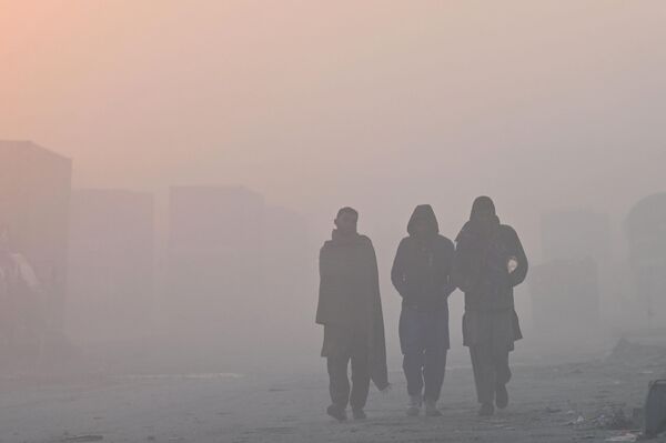 Men walk along a street amid heavy smog in Lahore on November 18, 2022. - Sputnik International